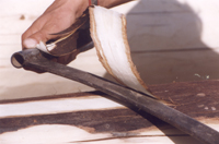 Hand-peeling a log with a draw knife